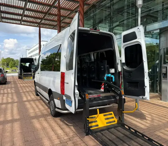 Professionele rolstoeltaxi chauffeur helpt klant in Weesp